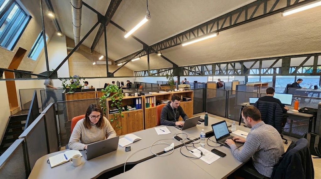 Équipe travaillant sur une mezzanine privatisée et lumineuse sous charpente métallique Chez NOO à Oullins.